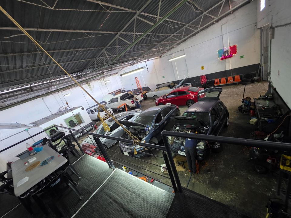 Interior del taller mecánico con varios vehículos en servicio